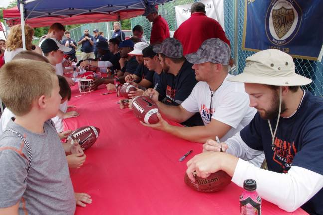 Former Tennessee Titans tight end Brett Brackett along with others autograph items for fans.
