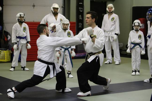 Black belts Frank Cutrone and Ryan Beebe demonstrate importance of sparring techniques.