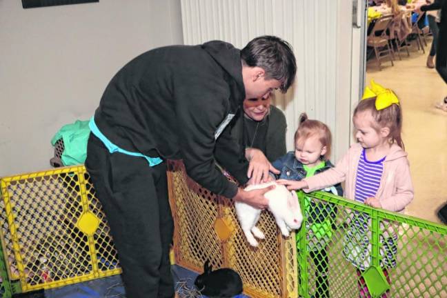 Brielle Caggiano, 3, and her sister Mila, 2, pet a rabbit at Breakfast with the Easter Bunny.