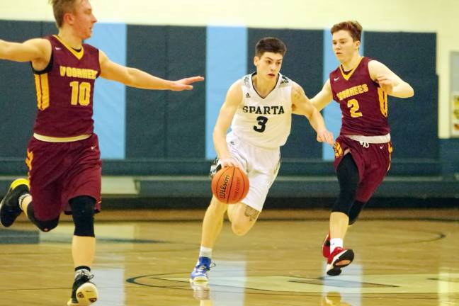 Sparta's Jack Cavanaugh dribbles the ball between to defenders. Cavanaugh scored a game high 19 points.
