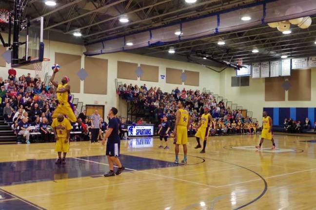 Harlem Wizard Lamarvon "Showtime" Jackson jumps over teammate Arnold "A-Train" Bernard during an amazing trick shot.