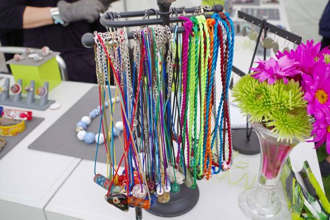 A display of handmade glass and metal jewelry created by artist Dawn Lombard.