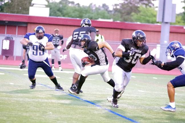 Central Pennsylvania Piranhas quarterback Dom Hobdy advances the ball through an opening in the Sussex Stags defense.