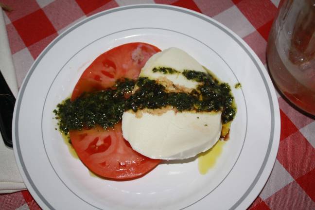 Farm to table ingredients: heirloom tomato with homemade mozzarella with pesto prepared by Caffe Anello of Westwood NJ.
