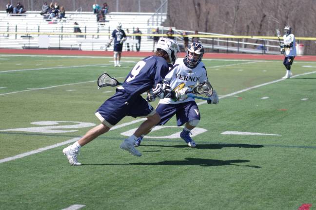 Pope John's Julian Canty carries the ball while facing Vernon's Larose. Photos by George Leroy Hunter