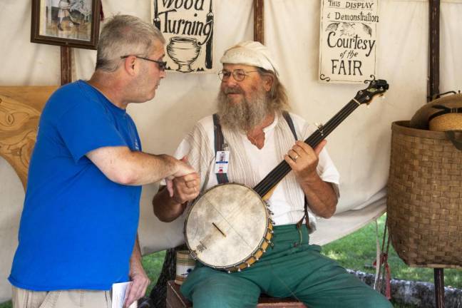 David Weed, left, of Frankford chats with woodworker and bowl turner Roger Abrahamson in his shop tent at the New Jersey State Fair. (Photo by John Hester)