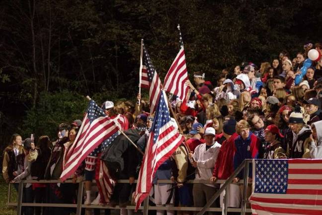 American flags are waved among Newton Braves football fans in the stands. (Photos by George Hunter).
