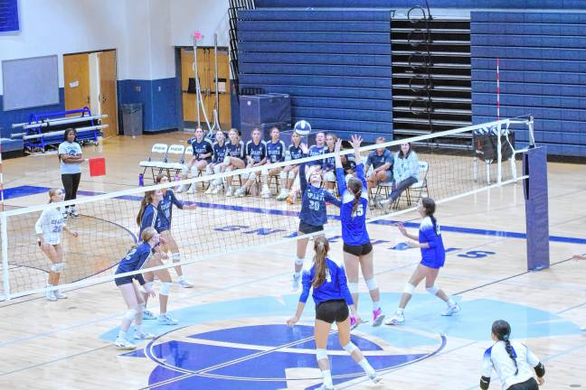 The Sparta Spartans and the Westfield Blue Devils battle on the volleyball court.