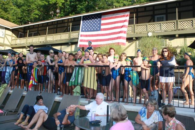 Lake Mohawk Pool Swim Team known as the Hawks gather for a team cheer before their season opener at home on July 5.