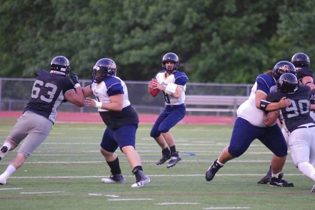 Sussex Stags quarterback Joseph Enslin holds the ball as his offensive line holds back the Central Pennsylvania Piranhas.