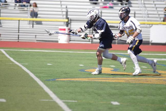 Pope John's Dane Armstrong carries the ball while shadowed by Vernon's Zack Biango. Armstrong picked up six ground balls.