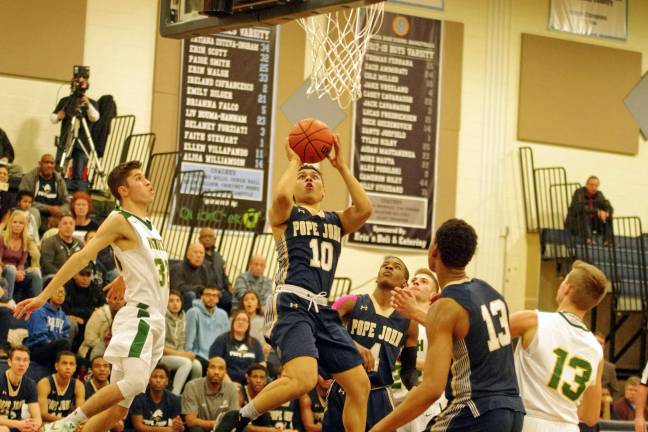 Pope John's Aaron Clarke takes the ball towards the hoop in the the fourth period. Photos by George Leroy Hunter