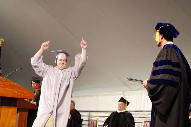 Sean Lockwood (Associate in Arts) of Vernon Township raises his arms in excitement as he is acknowledged during the graduation ceremony.