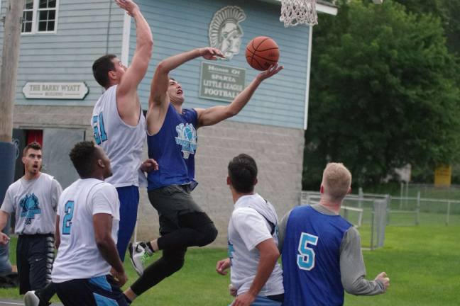Team Synol's Craig Tomkins takes the ball to the hoop while covered by Team Tobin's Almin Hodzic.