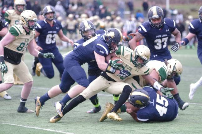 Saint Joseph ball carrier Isaiah Hopkinson is brought down by Pope John defenders.
