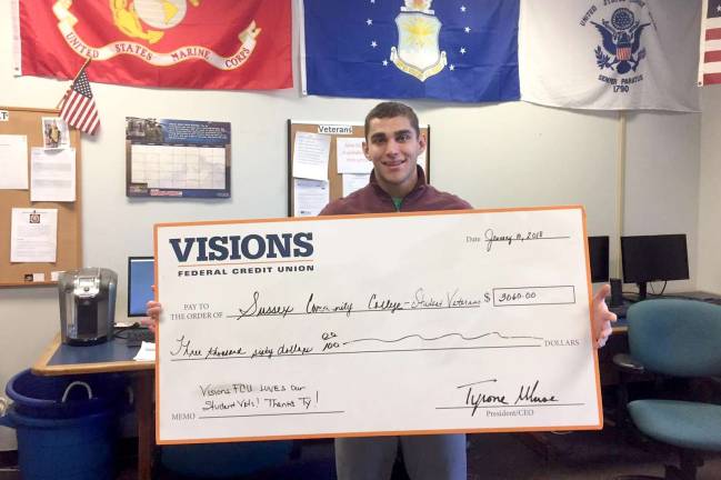 Jon Finocchiaro, veterans services coordinator at SCCC, holds the check donation presented by Visions Federal Credit Union. Photo provided