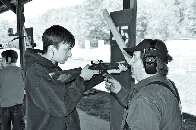 Life Scout Raymond Roggero shooting a black powder rifle.