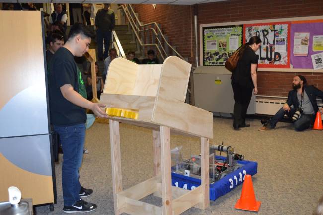 Nick Nannery demonstrates how gears are delivered to the robot