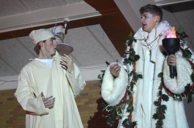 Senior Hunter Gallo, left, and junior Michael Lavin act out scene during rehearsal of the Pope John Players’ production of “A Christmas Carol” on Monday at Pope John XXIII Regional High School. In the show, Gallo plays the role of Ebenezer Scrooge, while Lavin plays the role of the Ghost of Christmas Present.