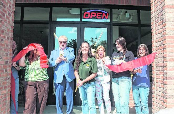 Greene’s Beans Cafe owner Kelsey Walter, center, cuts the ribbon.