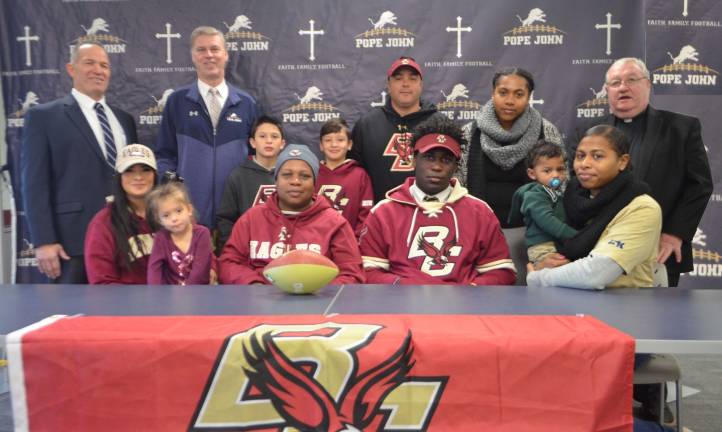 Pope John XXIII Regional High School senior defensive lineman Ireland Burke, seated second from right, signed onto Boston College on Wednesday. Seated next to Burke, from left, are Tina Brown, Burke&#x2019;s mother, Susan Bassaragh, and Burke&#x2019;s sister Stephanie. Standing in back are Pope John Principal Gene Emering, Pope John head coach Brian Carlson, Sean Brown, James Brown, Sean Brown and Burke&#x2019;s sister Sadieann.