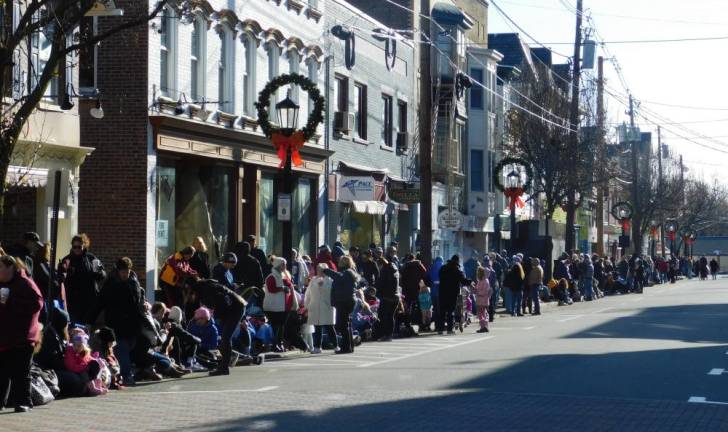 Residents bundle up against the cold to wait for the start of the Annual Holiday Parade in Newton on Saturday, Nov 30, 2019.