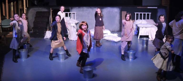 Danielle Perry as Annie, with orphans played (from left) by Jennifer, Catelina and Athena Kollar, Kora Garcia, Meghan Smith, grace Nagle, Audrey White. Emily Neillands and Lainey White