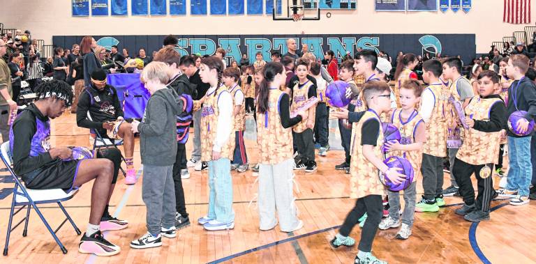 Children line up for autographs from the Harlem Wizareds