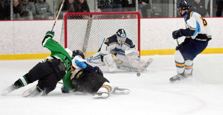 Sparta-Jefferson's goalkeeper Logan Hanek drops down in an attempt to intercept the puck as fellow hockey players collide on the ice in the second period. Hanek stopped 16 shots.