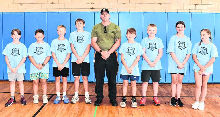 Office Brian Gallagher poses with Junior Police Academy participants.