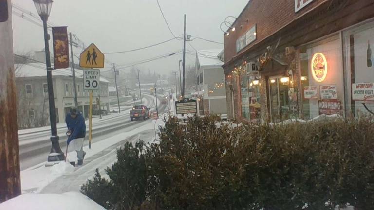 Freddie Martinez shovels in front of Mariela's Pizzeria as snow begins to fall in Sparta during a surprisingly harsh and unforgettable storm on Thursday, Nov. 8, 2018.