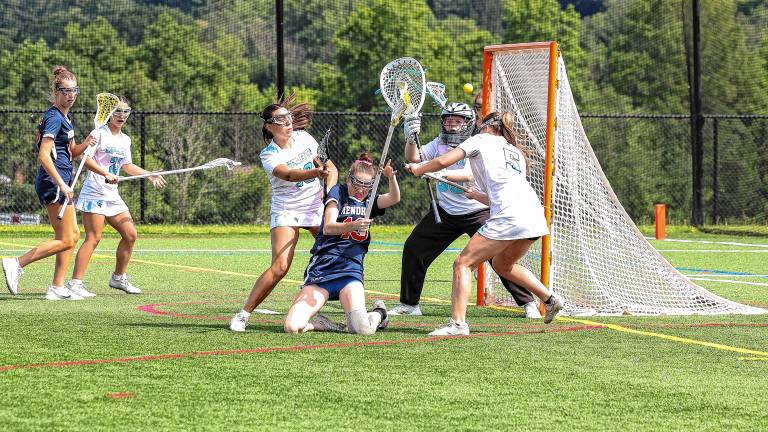 SL1 Mendham battles through a tight Sparta defense to fire off a shot in the first half of the NJSIAA North Jersey, Group 2 championship game Tuesday, June 10. The Spartans defeated Mendham, 8-4, then lost to Allentown, 6-5, in the Group 2 final Friday, June 13. (Photo by Lauren Clark)