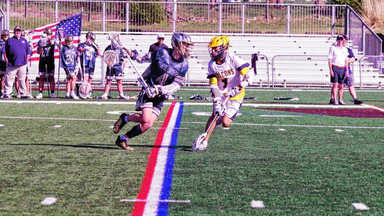 Pope John's Peyton Fox (4) runs with the ball as he faces Jefferson's Calen Reid on April 28. The Lions won, 12-4, and Fox scored two goals. (Photos by George Leroy Hunter)