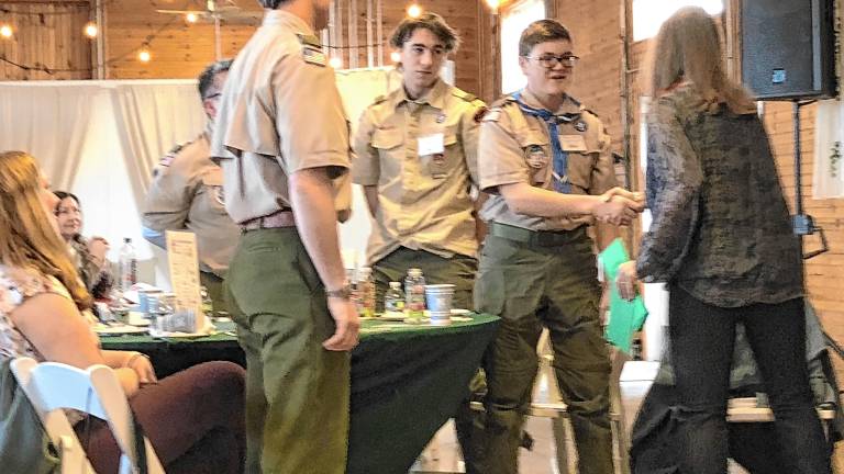 <b>Sabine Watson, right, president of the German Christmas Market of New Jersey, presents a check to members of Scouting America Troop 150 of Sparta. (Photos by Kathy Shwiff)</b>
