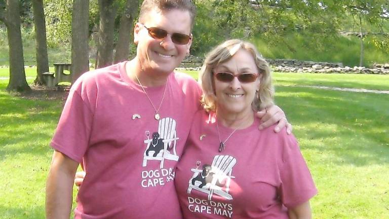 Jose and Marie Flores wearing their Dog Days in Cape May tee-shirts honor their dog Onyx. That was Onyx’s last vacation with the couple. (Photo by Janet Redyke)