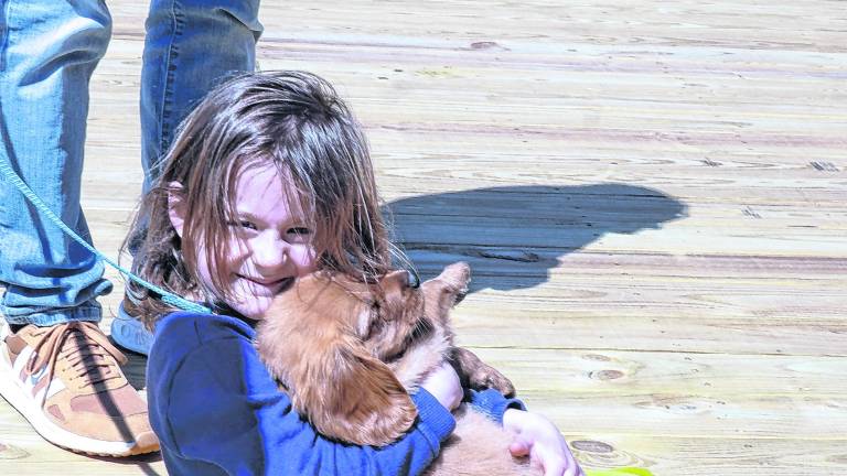 Abigail Ryan holds a dog, Cooper.
