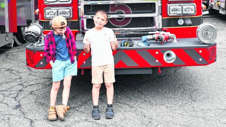 Michael Yanko and Colton Steffen of Sparta pose in front of a fire truck.