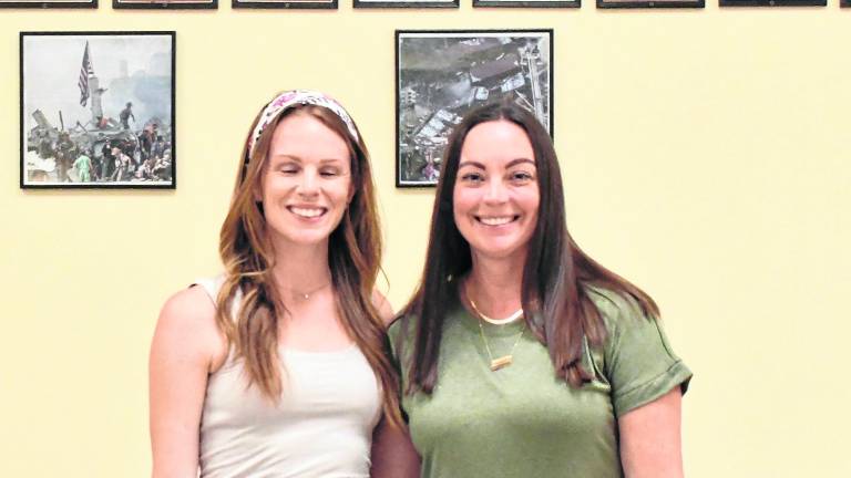 Lindsey Brown of Rooted Yoga and Melissa wright of Rooted by Wrights pose behind plants.