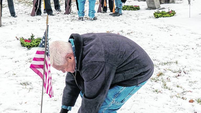 Chris Kuever places a wreath.