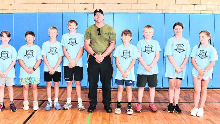Office Brian Gallagher poses with Junior Police Academy participants.