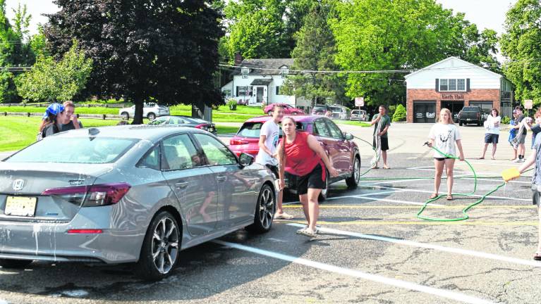 Members of the Marching Spartans wash a car.