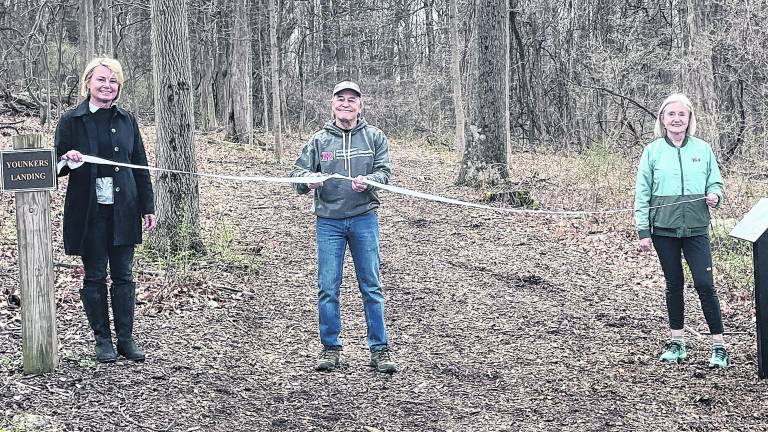 From left, Anne Lopuch, Neil Saurwein and Christine Dunbar hold the ribbon.